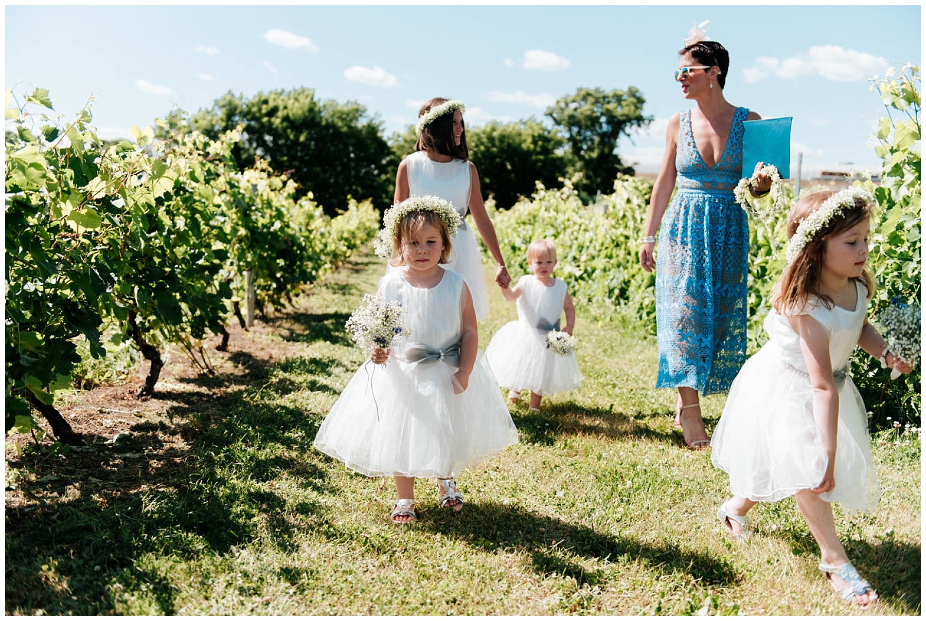 Les petites bouquetière avancent entre les vigne avec leurs petites robes blanches et leur bouquet de fleur à la main.