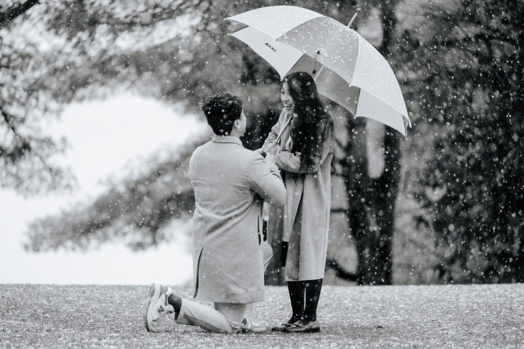 Man proposing on one knee in the snow at Ripple Cove in Ayer's Cliff, Eastern Townships — candid spring proposal photography near Montréal