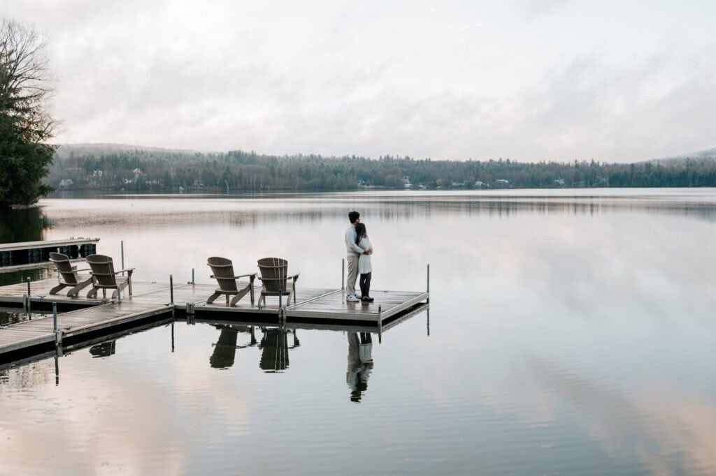 Couple standing together on the dock at Ripple Cove in Ayer's Cliff, reflected in the still lake waters — South Shore of Montréal proposal photographer