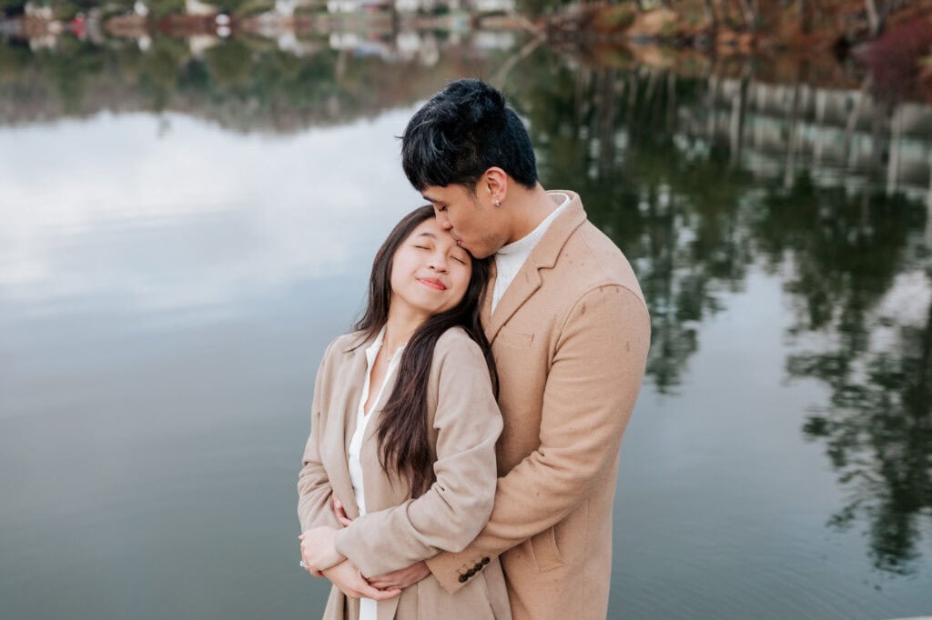 Engaged couple embracing by the lake at Ripple Cove in Ayer's Cliff, Eastern Townships